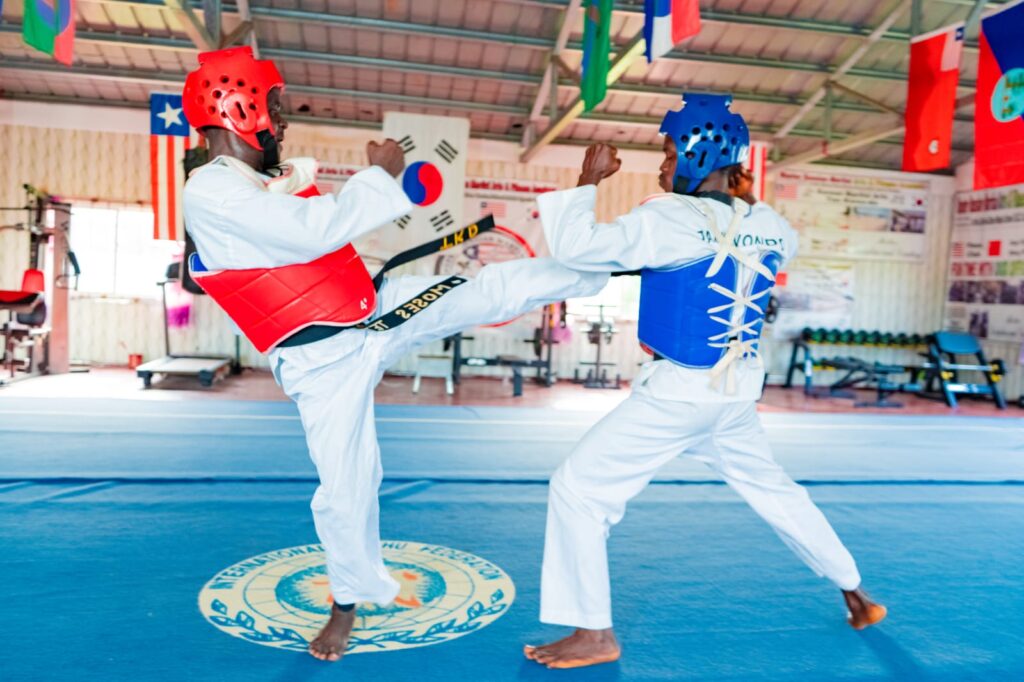 Two young men competing in a Taekwondo match.